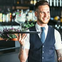 Bartender holding glass smiling